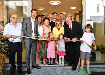 Generationenhaus in Pfaffstätten Bestimmung übergeben. Bewohner Alfred Haselmann, Christian Rädler von der Wohnbaugesellschaft WET, Bezirkshauptfrau Verena Sonnleitner, die Leiterin des Generationenhauses Iris Rodlauer, Vizebürgermeisterin Johanna Stadlmann, Pater Amadeus Hörschläger, der Badener Bürgermeister Stefan Szirucsek, Landeshauptfrau Johanna Mikl-Leitner, der Traiskirchner Bürgermeister Andreas Babler,  Bürgermeister Christoph Kainz und die Leiterin der Kindergrippe Sandra Ohlau-Fischer (v.l.n.r) mit Kindern