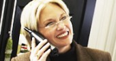 Abbildung einer 30 - 40 jährigen blonden Frau die mit einem Handy telefoniert