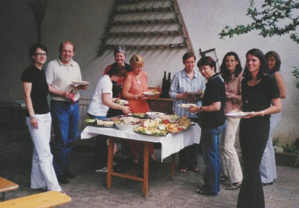 10 Personen beim Heurigen, in der Mitte ein Buffet