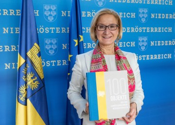 Landeshauptfrau Johanna Mikl-Leitner mit dem Buch „100 Objekte aus  den Landessammlungen“.