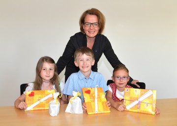 Familien-Landesrätin Christiane Teschl-Hofmeister mit Kindern, die ihre Muttertags-Geschenke im Kindergarten vorbereitet haben: Gloria Sieber, Alexander Biber und Lena Halmschlager (v.l.n.r.)