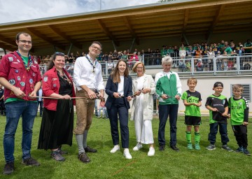 Neue Begegnungszone beim Sportplatz mit Vereinshaus: Gruppenleiter Benjamin Veitschegger und Julia Böhm, Pfadfinder-Obmann Alexander Hammerl, Bürgermeisterin Bernadette Geieregger, Landeshauptfrau Johanna Mikl-Leitner, ASK-Obmann Gerhard „Jerry“ Wagner und Kinder (v.l.n.r.) 