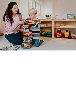 Kindergärtnerin und Kind spielen mit Bauklötzen