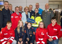 (v.l.n.r.) Bezirksfeuerwehrkommandant Georg Schröder, NÖ Samariterbund-Präsident Hannes Sauer, Präsident NÖ Rotes Kreuz Hans Ebner, Landesleiter Wasserrettung Markus Schimböck, Landeshauptfrau Johanna Mikl-Leitner, NÖ Landespolizeidirektor Franz Popp, Anita Zinner vom Notruf NÖ, NÖ Zivilschutzverband-Präsident Landtagsabgeordneter Christoph Kainz, NÖ Militärkommandant Georg Härtinger und (vorne kniend) die jungen Freiwilligen von Rettung und Feuerwehr.